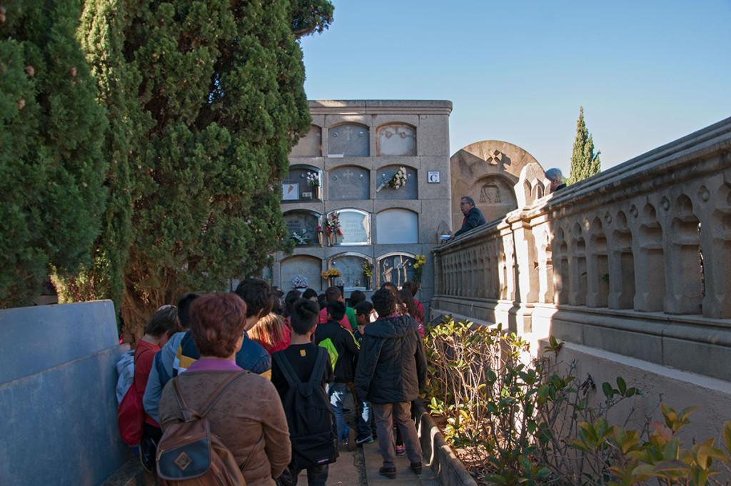 Un grup d’escolars escolten les explicacions del professor sobre el poeta Espriu davant la seva tomba